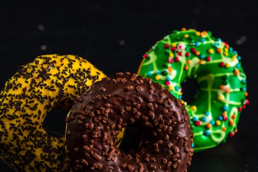 Glazed donuts with sprinkles isolated. Close up of colorful donuts.