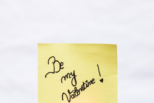 Be my valentine handwriting text close up isolated on yellow paper with copy space.