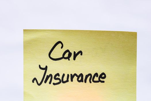 Car insurance handwriting text close up isolated on yellow paper with copy space.