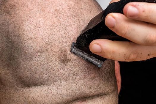 Man shaving or trimming his hair using a hair clipper