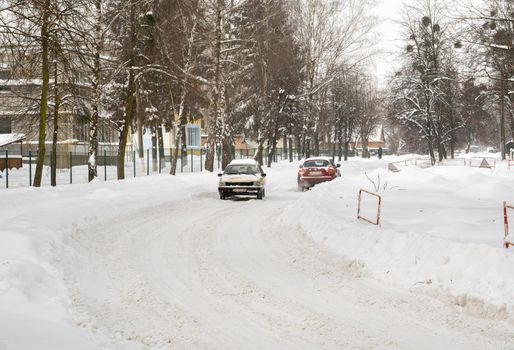 Lutsk, Ukraine - February 12,2020: People on street after snow storm. City street after blizzard. Record-breaking amounts of snow. Uncleaned slippery roads and sidewalk in winter. Cars in snowdrift