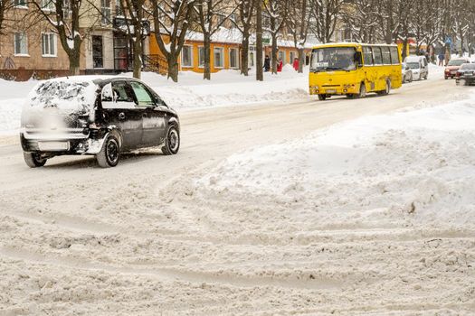 Lutsk, Ukraine - February 12,2020: People on street after snow storm. City street after blizzard. Record-breaking amounts of snow. Uncleaned slippery roads and sidewalk in winter. Cars in snowdrift