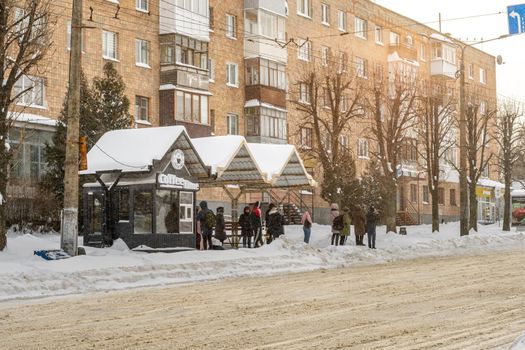 Lutsk, Ukraine - February 12,2020: People on street after snow storm. City street after blizzard. Record-breaking amounts of snow. Uncleaned slippery roads and sidewalk in winter. Cars in snowdrift