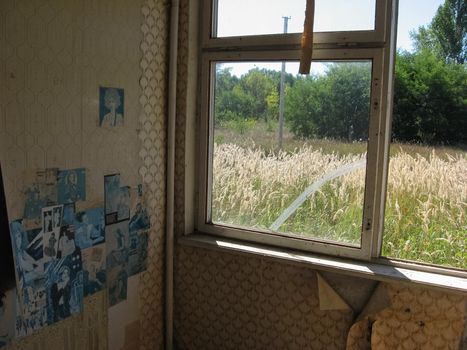 Ancient posters of the 80s and 90s on the wall of an abandoned house.