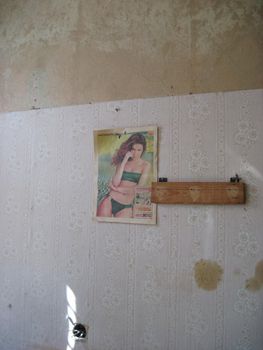 Ancient posters of the 80s and 90s on the wall of an abandoned house.