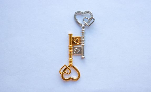Gold and silver keys, with hearts isolated on a white background.