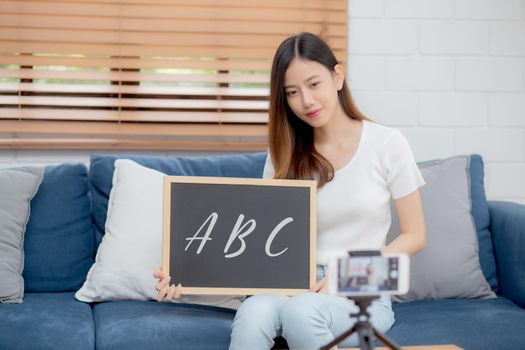 Young asian woman is teacher teaching language english with student for e-learning online at home, girl working and talking lesson in class with smartphone, stay home, new normal, education concept.