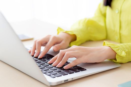 Closeup of hand young asian businesswoman working on laptop computer on desk at home office, freelance looking and typing on notebook on table, woman studying online, business and education concept.