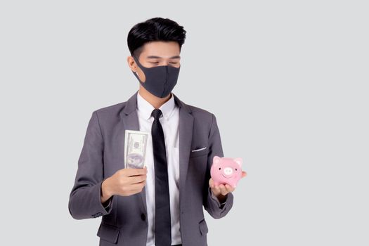 Young asian businessman in face mask holding money dollar and piggy bank isolated on white background, crisis of economic, business man in mask investment finance and saving during disease covid-19.