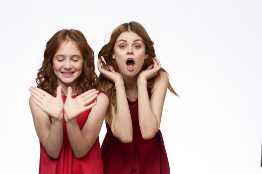 Mom and little daughter wearing red dresses joy friendship lifestyle light background. High quality photo