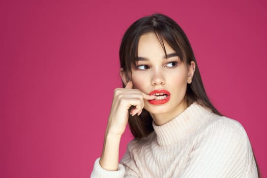 Woman with long hair and red lips white blouse pink background attractive look. High quality photo
