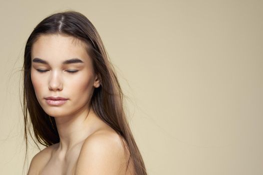 Pretty woman naked shoulders long hair body care beige background. High quality photo