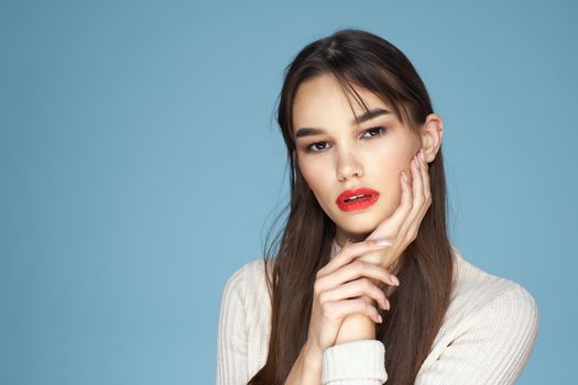Brunette in white sweater red lips charm cropped view blue background. High quality photo