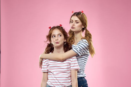 funny girlfriends with clothespins hair on a pink background sisters. High quality photo