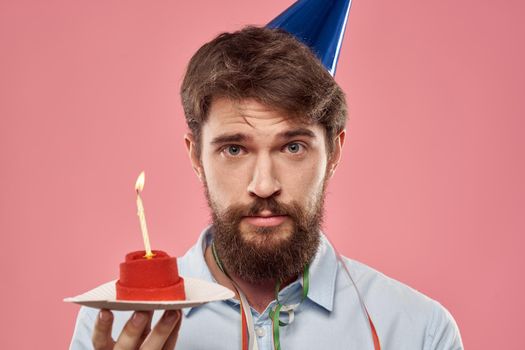 Happy car with a cake on a pink background and in a cap in Copy Space holidays birthday. High quality photo