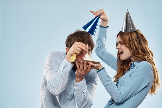 Birthday corporate young man and woman with cake on isolated background disco party. High quality photo