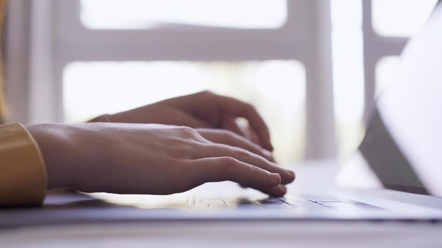 female hands are typing text on laptop work is internet close-up. High quality photo