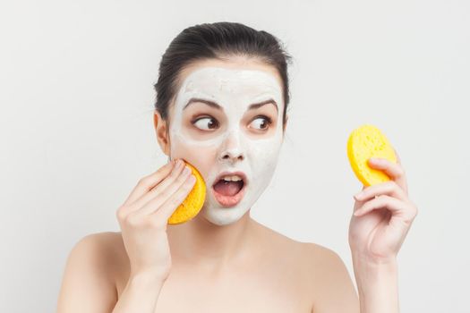 pretty woman with bare shoulders with bum in hands removing mask from face. High quality photo