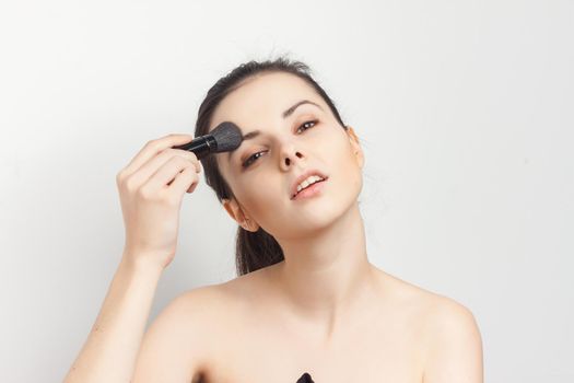 attractive brunette with bare shoulders facial masking skincare. High quality photo