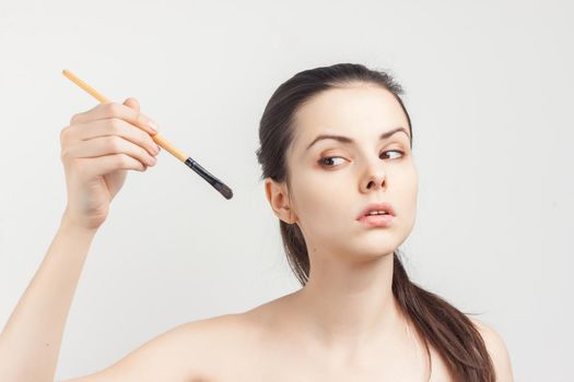 pretty woman with bare shoulders is in hand applying cosmetics skin care. High quality photo