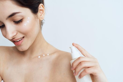 Pretty brunette naked shoulders skin care lotion. High quality photo