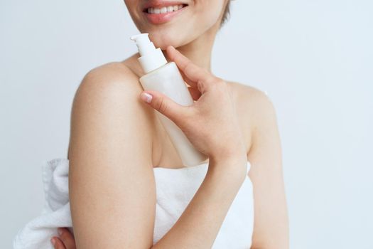 Pretty woman in white towel naked shoulders lotion clean skin hygiene. High quality photo