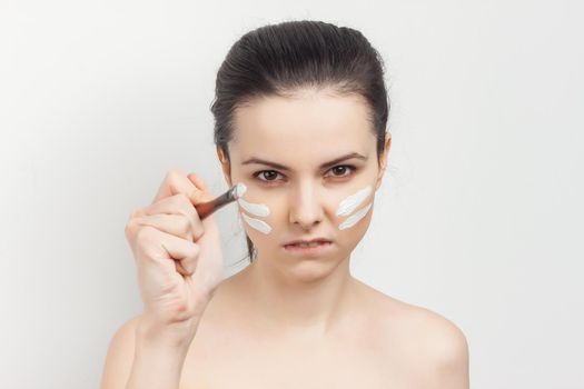 woman applying makeup brush on face skin care. High quality photo