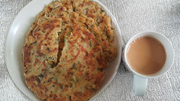 Closeup view of of traditional bread called Jawar roti or bhakri with tea cup. Bhakri is a round flat unleavened bread often used in the cuisine of many Asian countries