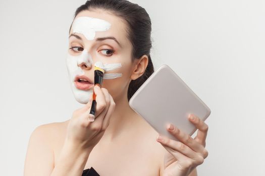 brunette with face mask naked shoulders skincare. High quality photo