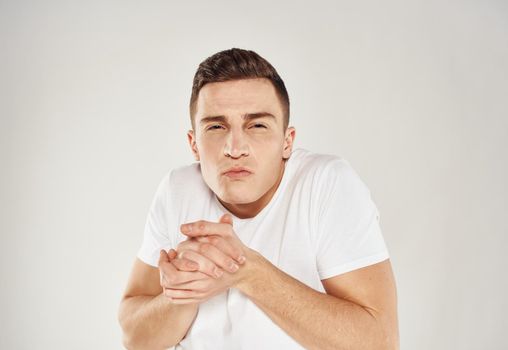 Nice guy in a white T-shirt on a light background cropped view portrait close-up. High quality photo