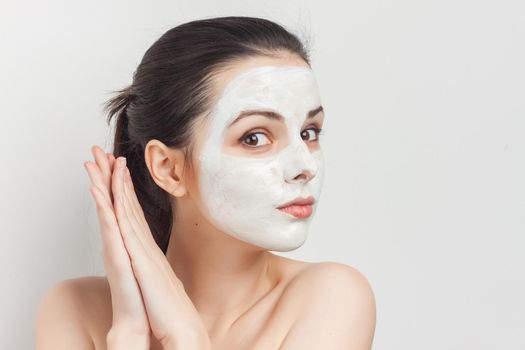 pretty brunette with bare shoulders gathered hair mask facial cream. High quality photo