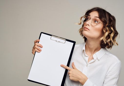 Portrait of a woman in a classic suit with a folder of documents on a gray background Copy Space. High quality photo