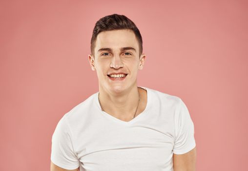 handsome man in white t-shirt emotions joy pink background. High quality photo