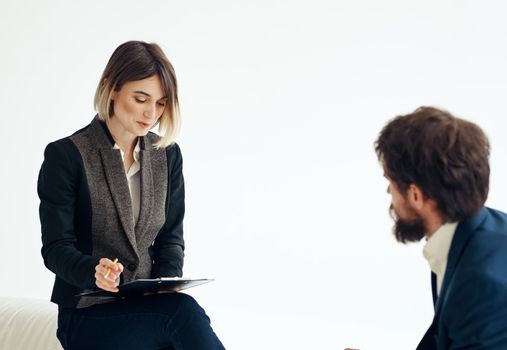 Business woman in a classic suit and a man in a jacket on a light background opposite each other. High quality photo