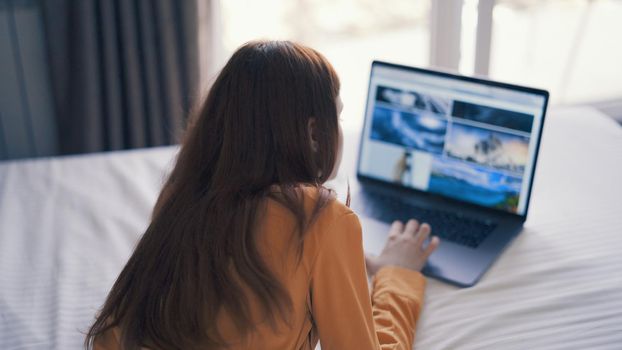woman in front of laptop lies bed lifestyle freelance. High quality photo