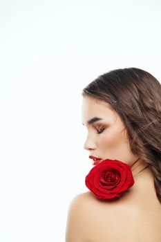 Back view of attractive brunette with red rose on naked shoulder. High quality photo