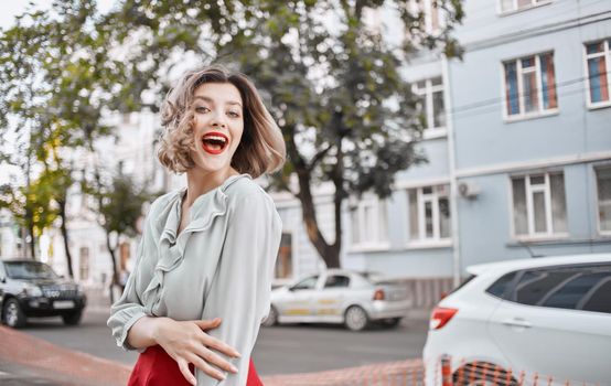beautiful blonde with red lips outdoors near the building gestures with her hands emotions Copy Space. High quality photo