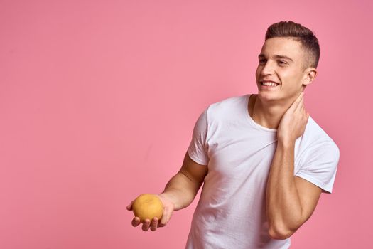 Cheerful man white t-shirt food diet pink background. High quality photo