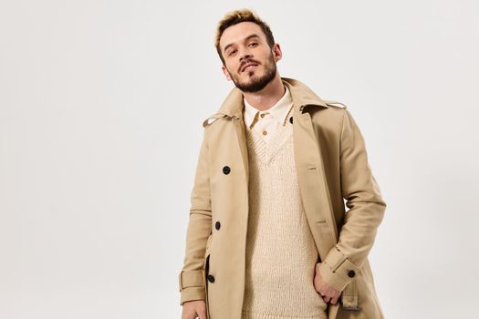 man in beige coat fashionable hairstyle attractive look Studio. High quality photo