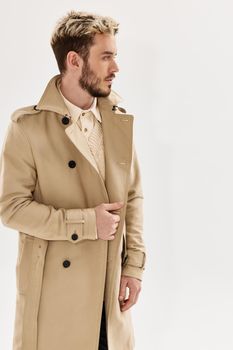 man with trendy hairstyle in beige coat modern style autumn clothing. High quality photo
