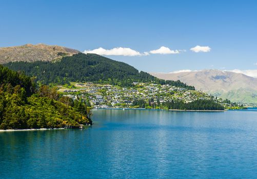 Beautiful blue lake Wakatipu near Queenstown with mighty Southern Alps mountains on horizon. Otago region, New Zealand. 