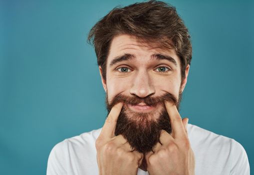 The sad man touches his face with his fingers not a real smile. High quality photo