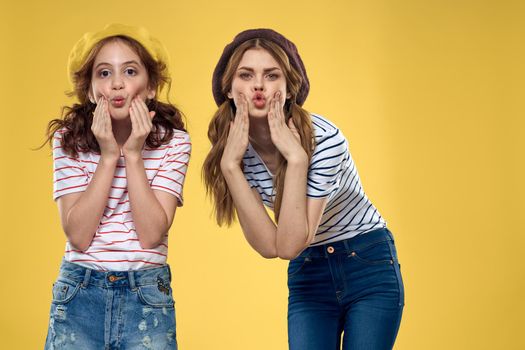 funny mom and daughter fashion clothes studio lifestyle yellow background. High quality photo