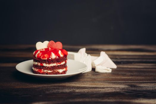 Round red cake on a plate marmalade sweets dessert wooden table. High quality photo