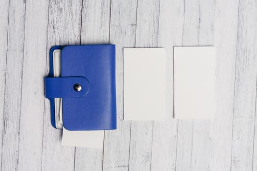 blue business card holder and white letterheads on a wooden table Copy Space. High quality photo