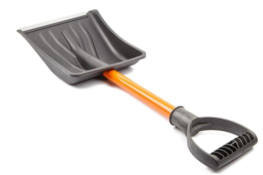 small plastic snow shovel, isolated on white background - back side, laid down, diagonal perspective handle toward camera