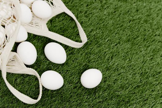 white eggs in a bag lie on the lawn top view Spring holiday Easter. High quality photo