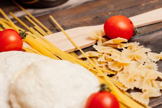 italian pasta on a wooden table cherry tomatoes cooking lunch. High quality photo
