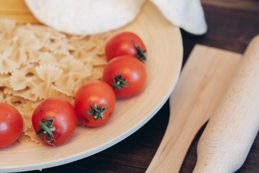 italian pasta on a wooden table cherry tomatoes cooking. High quality photo