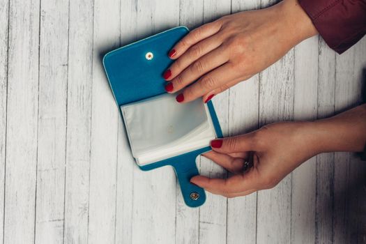 business card holder in female hands on a wooden background texture and bright varnish. High quality photo